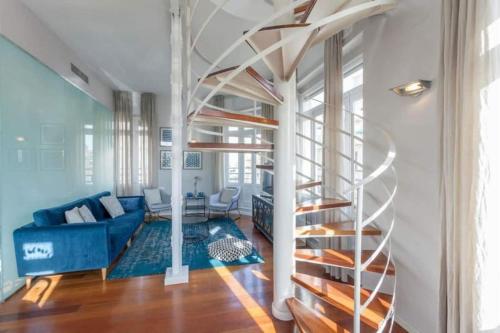 a spiral staircase in a living room with a blue couch at San Vicente in Valencia