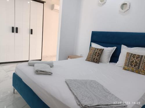 a large bed with a blue headboard in a room at LEO Haute standing appartment S1 center Monastir in Monastir