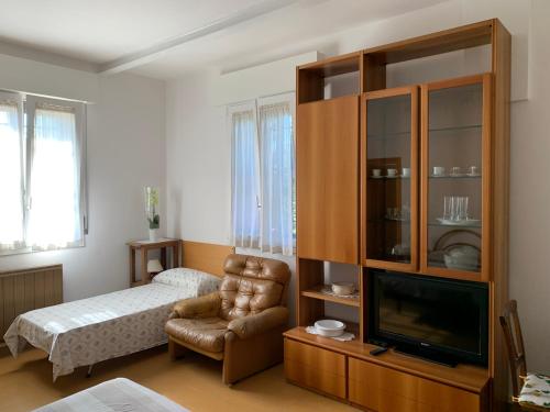 - une chambre avec un lit, une télévision et une chaise dans l'établissement Al sit ed Marino, à Castel Maggiore