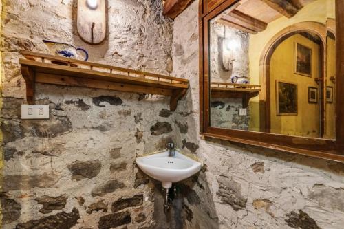 a stone bathroom with a sink and a mirror at Casa Teresina in Collodi