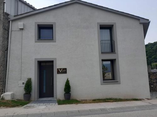 a white house with a sign that says vaan at Apartaments Vall del Corb 1 Garrotxa in San Miguel del Corp