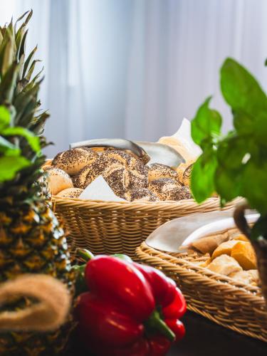 a table topped with baskets of bread and a pineapple at Focus Hotel Szczecin in Szczecin