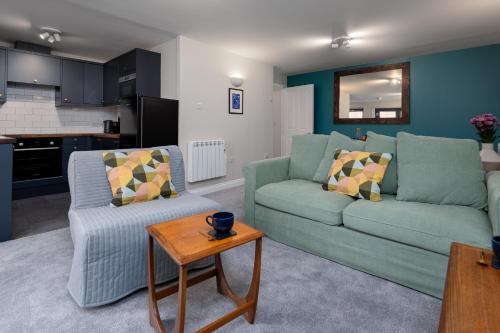a living room with two green couches and a table at Modern 2 Bedroom Apartment with Parking by At Hem in Southampton