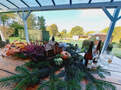 una mesa con botellas de vino y fruta. en Les marmottes - Maison de vacances La Roche-en-Ardenne, en La-Roche-en-Ardenne