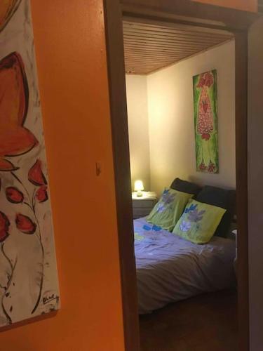 a bedroom with a bed and a painting on the wall at La Petite maison in Montleban