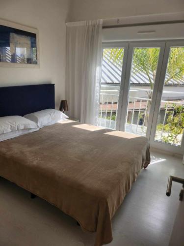a bedroom with a large bed and large windows at Bleu Mer Duplex & Suites in Saint-Cyprien