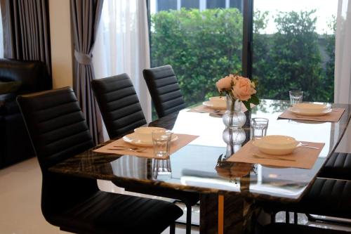 mesa de comedor con sillas y ventana grande en Cheri’s homestay现代两层独栋别墅，4卧4卫，3日送接机1周接送机,近Mega邦纳, en Bangkok