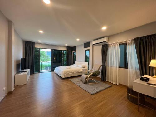 Dormitorio con cama, escritorio y TV en Cheri’s homestay现代两层独栋别墅，4卧4卫，3日送接机1周接送机,近Mega邦纳, en Bangkok
