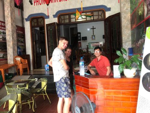 three men standing at a bar in a restaurant at Phong Nha Backpacker Hostel in Cừ Lạc