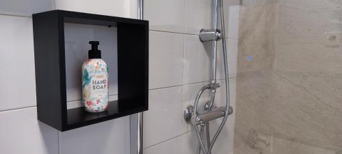 a bottle of soap is on a shelf in a shower at Casa Rural Crisol Spa in Arenas de San Pedro