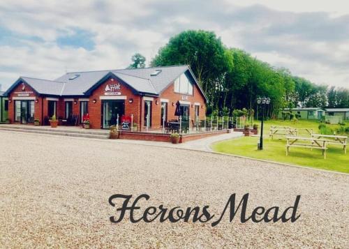 a red building with the words horizons need at Herons Mead Touring Park and Fishing Lakes - Plot 18 in Orby