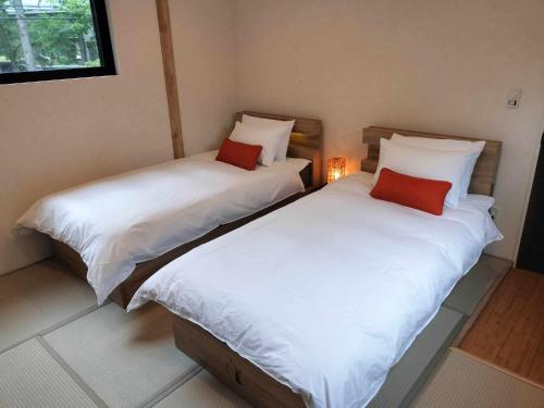 two beds sitting next to each other in a room at Nestle Inn Hakuba in Hakuba