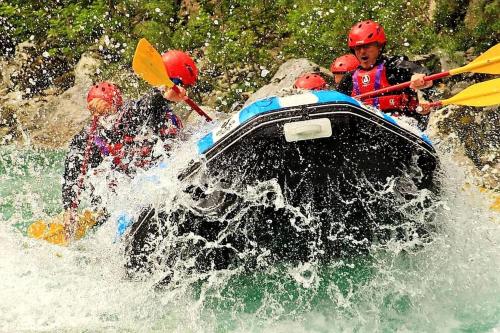 a group of people on a raft in a river at Studio Mobile Home Gotar in Kobarid