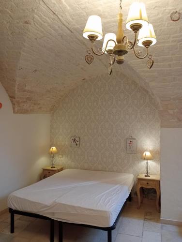 a bedroom with a white bed and two night tables at Appartamento la Birba in Alberobello