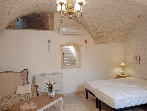 ein Schlafzimmer mit einem Bett und einem Stuhl in einem Zimmer in der Unterkunft Appartamento la Birba in Alberobello