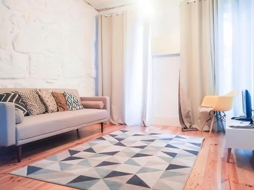 uma sala de estar com um sofá e um tapete xadrez em Serpa Beach House em Matosinhos