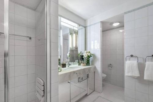 een witte badkamer met een wastafel en een spiegel bij Lake View Montreux Jazz Festival in Montreux
