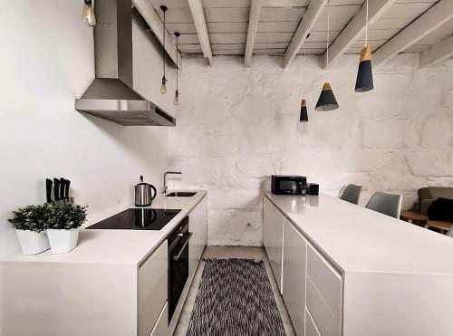 a kitchen with white cabinets and a counter top at Serpa Beach House in Matosinhos