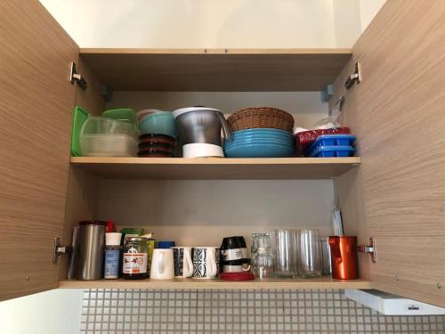 a cupboard with bowls and plates and other items at Appartement Chania Centrum in Chania Town