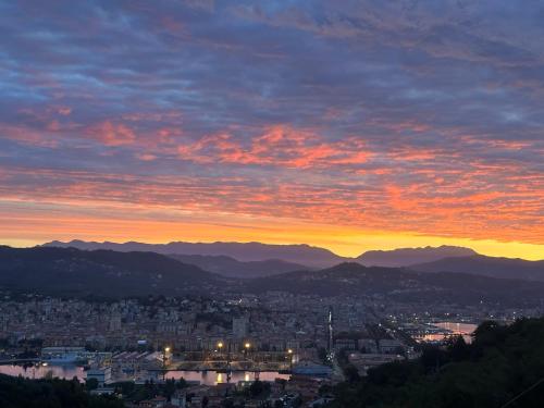 a sunset over a city with mountains in the background at Affittacamere Via Prione in La Spezia