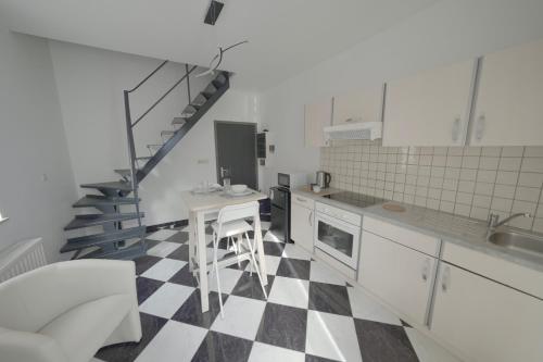 uma cozinha com piso em xadrez preto e branco em Studio Didine em Charleroi