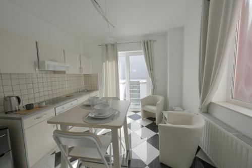 Una cocina con una mesa y sillas en una cocina. en Studio Didine, en Charleroi