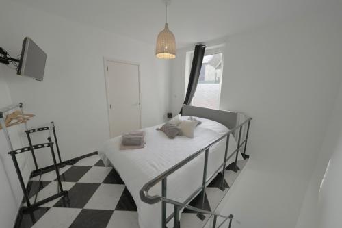 Habitación blanca con cama y ventana en Studio Didine, en Charleroi