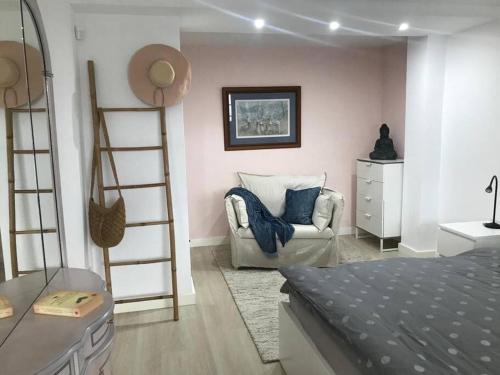 1 dormitorio con 1 cama, 1 silla y 1 escalera en Strandnahes Ferienappartment in bester Lage!, en Puerto de la Cruz
