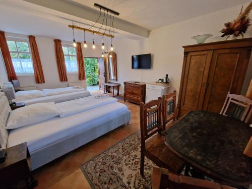 1 dormitorio con 2 camas, mesa y TV en Gasthof Reuner, en Glashütte