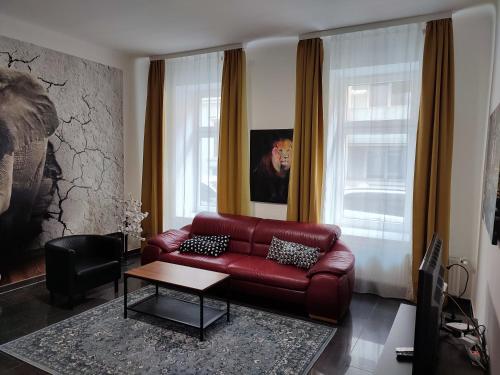 - un salon avec un canapé en cuir rouge et une table dans l'établissement Apartment with living room, 2 bedrooms, balcony, à Vienne