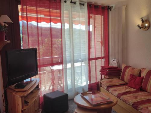 een woonkamer met een bank en een groot raam bij Studio Villard-de-Lans, 2 pièces, 4 personnes - FR-1-689-44 in Villard-de-Lans