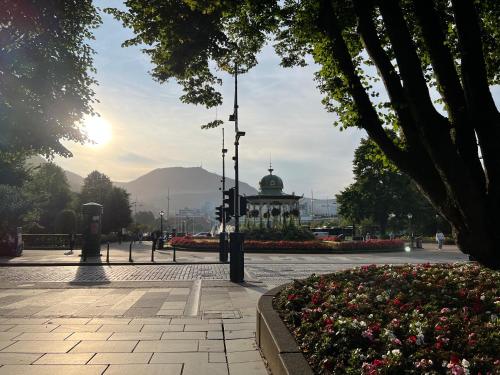 a park with a building in the distance with flowers at Vestre Torggaten 20 in Bergen