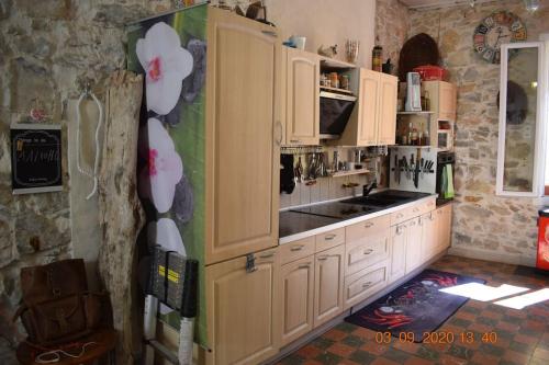 uma cozinha com armários brancos e um frigorífico em Sète centre ville APPARTEMENT ATYPIQUE F2 (70 m²) em Sète