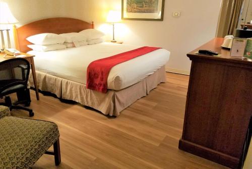 a hotel room with a large bed and a desk at Ramada by Wyndham State College Hotel & Conference Center in State College