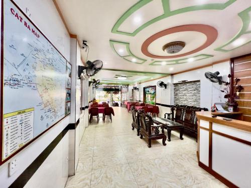 a restaurant with tables and chairs and a map on the wall at Manh Vuong Hotel in Cat Ba