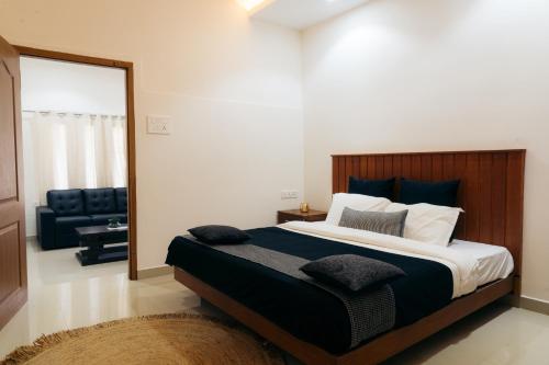 a bedroom with a large bed and a couch at La Cascade Resort in Athirappilly