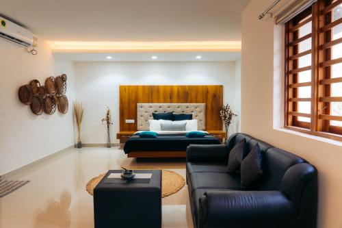 a living room with a bed and a couch at La Cascade Resort in Athirappilly
