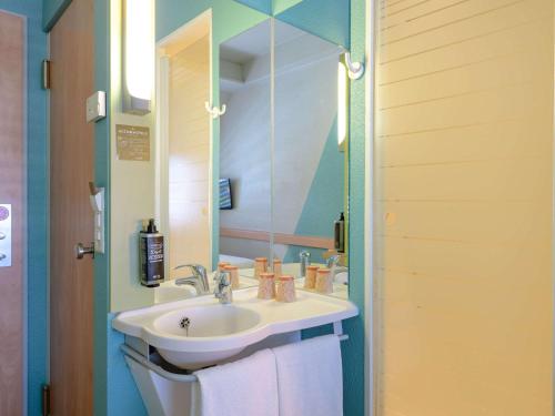 La salle de bains est pourvue d'un lavabo et d'un miroir. dans l'établissement ibis budget Hotel Luzern City, à Lucerne