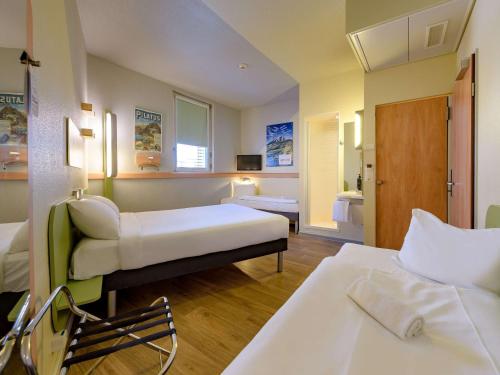 a hotel room with two beds and a bathroom at ibis budget Hotel Luzern City in Luzern