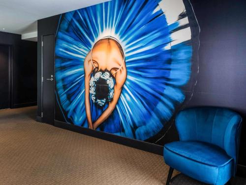 a wall with a painting of a woman in blue at Ibis Christchurch in Christchurch
