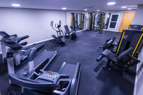 a gym with several treadmills and cardio machines at Hotel Caiuá Blumenau in Blumenau