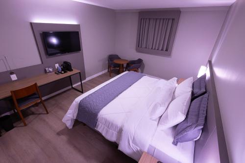 Postel nebo postele na pokoji v ubytování Hotel Caiuá Blumenau