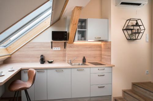 a kitchen with white cabinets and a sink and a window at Theatre 9 Apartments by Adrez in Prague