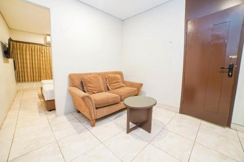 a living room with a chair and a table at Hotel Kalisma by Alia in Jakarta