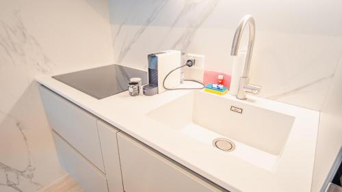 Baño blanco con lavabo y grifo en Garda Luxury Suite - Italian Homing, en Padenghe sul Garda