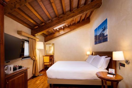 a hotel room with a bed and a television at Best Western Plus Hotel Le Rondini in San Francesco al Campo