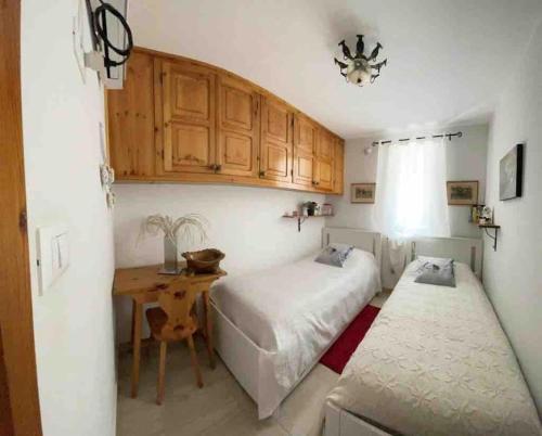 1 dormitorio con 2 camas, mesa y armarios en Full Apt x 6 to ski resort 4 km en Villaret