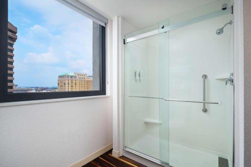 a glass shower in a bathroom with a window at Hampton Inn & Suites - Richmond - Downtown, VA in Richmond