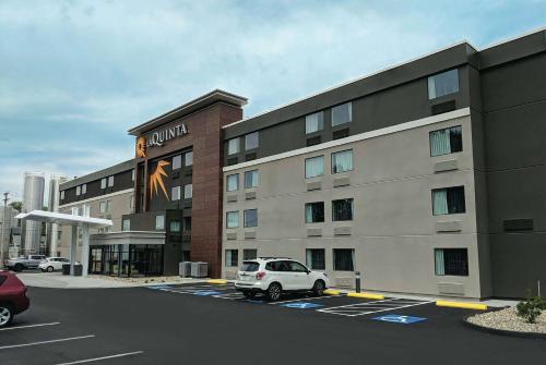 a building with a white car parked in a parking lot at La Quinta by Wyndham Portland in Portland