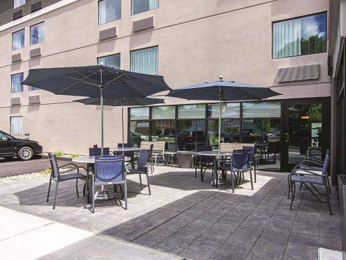 a patio with tables and chairs with umbrellas at La Quinta by Wyndham Portland in Portland